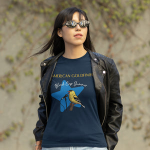 Navy unisex bird shirt featuring an American goldfinch singing into a microphone with a list of dates and cities on the back where the bird is commonly seen. Worn by a woman in a leather jacket and sun glasses, because she is cool.