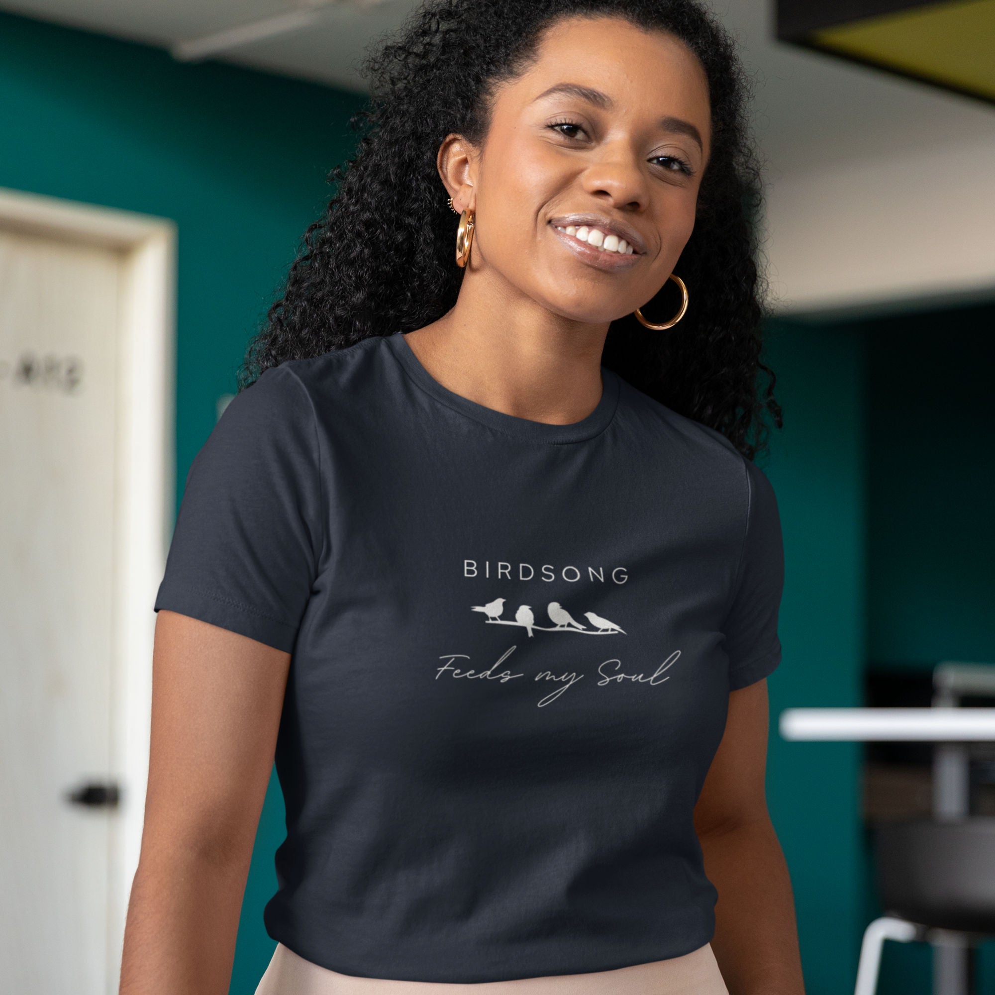 Navy blue women's bird t-shirt with the words Birdsong feeds my soul placed above and below a white graphic of 4 birds on a branch.