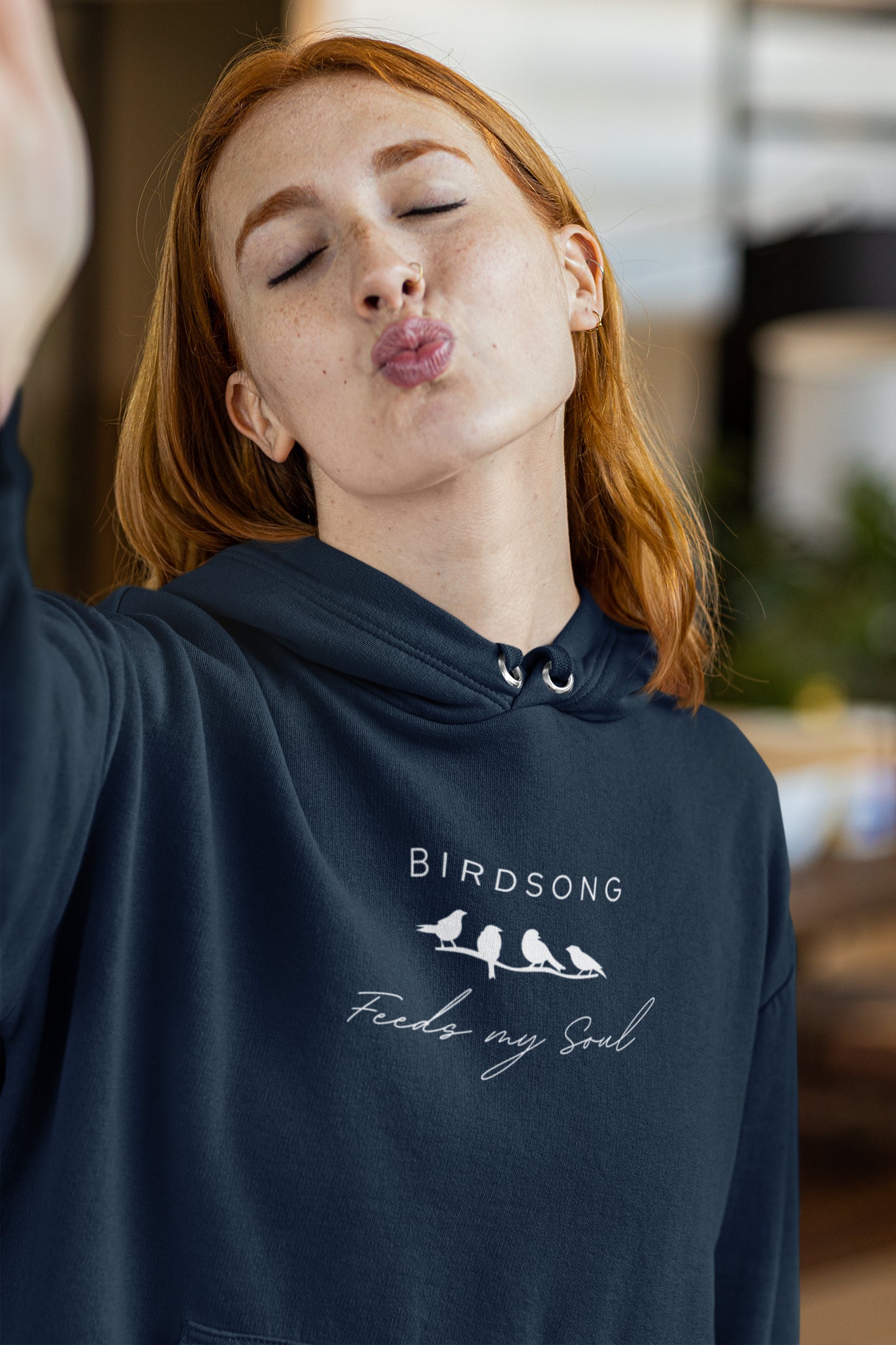 Navy hoodie with the words Birdsong feeds my should above and below a white graphic of 4 birds on a branch.