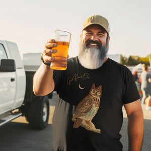 Black bird shirt with vintage owl art and the words "Great Horned Owl" on the top right. Worn by a bearded man at a tailgating party.