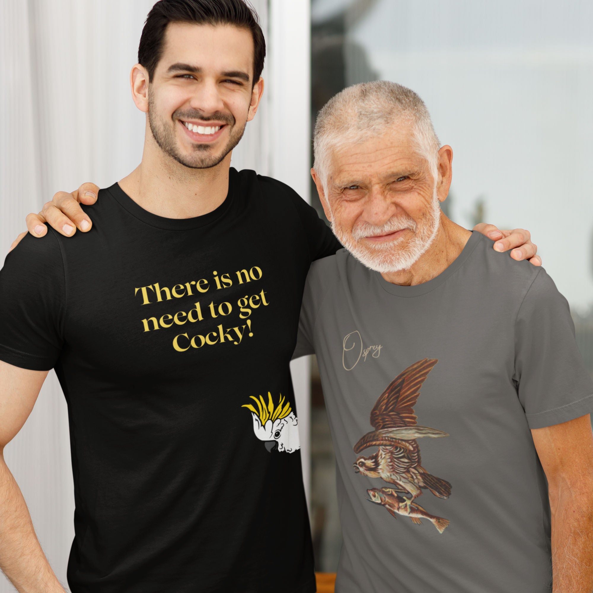 Black bird shirt with the words, "There is no need to get Cocky!" on the front with a sulfur crested cockatoo peeking in from the side. Worn by a man standing next to his father and posing for a picture. Dad is wearing a pretty sweet Osprey shirt.