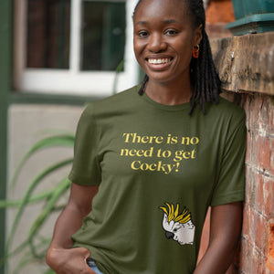 Olive green bird shirt with the words, "There is no need to get Cocky!" on the front with a sulfur crested cockatoo peeking in from the side. Worn by a woman leaning against a wall.