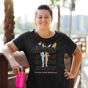 Black unisex birding t-shirt that has silhouettes of a man and a woman using binoculars overlayed on a stack of the word Birds with the saying, "Never Stop Birding" at the bottom and colorful silhouette of different birds at the top. Worn by a woman sweating from working out..