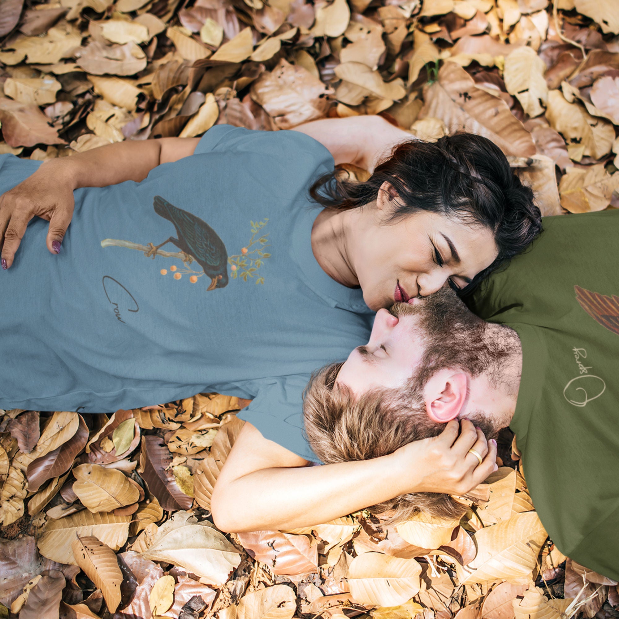 Blue bird shirt with vintage artwork of a crow and the word "Crow" written on the bottom left. Worn by a woman smooching on her boyfriend while laying on a pile of leaves. Because crow bird shirts are romantic.