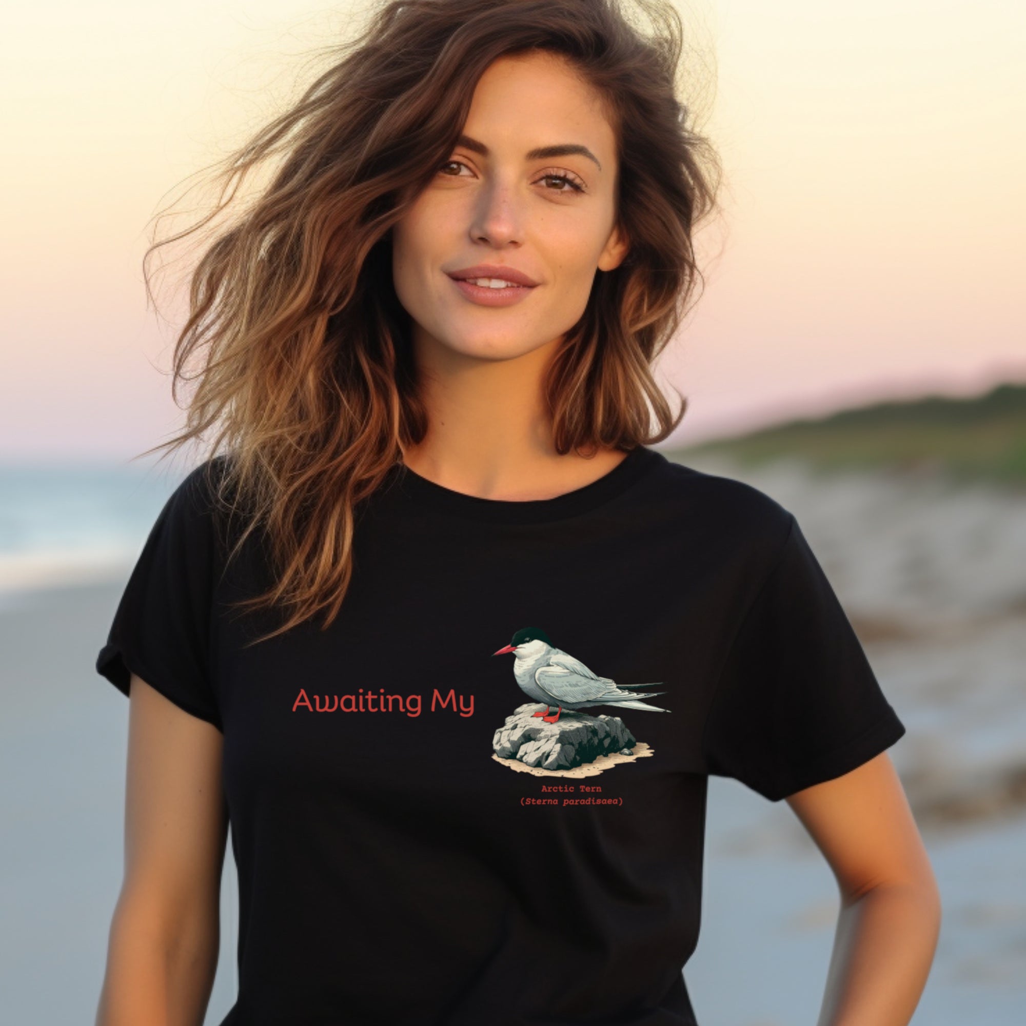 Black unisex crew neck t-shirt with a graphic of an Arctic Tern on a rock, and the words "Awaiting My" next to it in a fun pun. The words Arctic Tern and the scientific name of Sterna Paradisaea are below the bird.