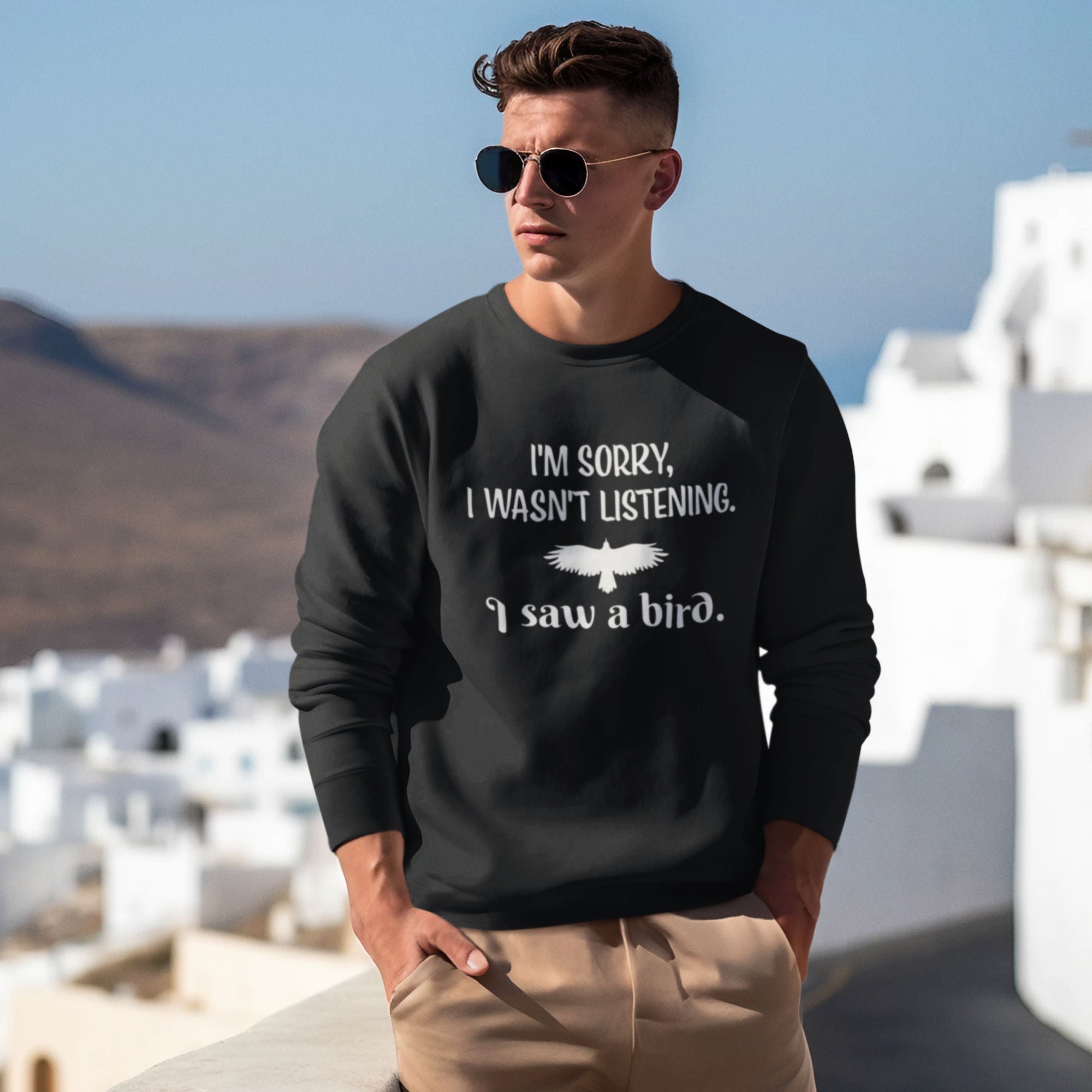 Black unisex bird sweatshirt with the words I'm sorry I wasn't listening, I saw a bird. And a graphic of a bird flying.