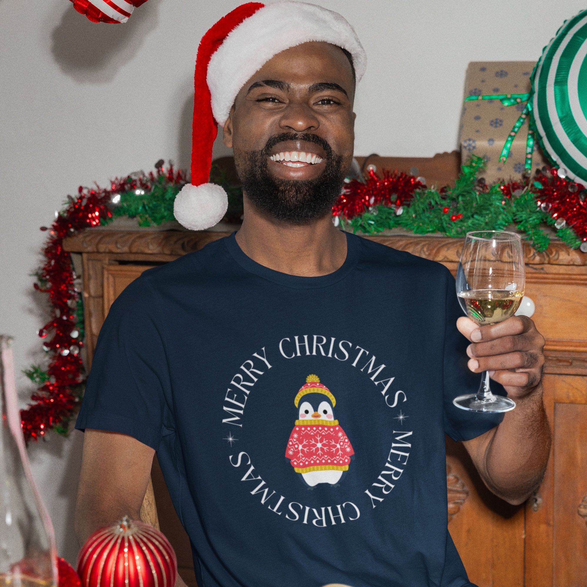 Navy blue unisex bird t-shirt with Merry Christmas on the front in a circle that surrounds a cute penguin in a hat and a sweater.