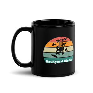 Black bird mug with a retro sun design outlining a bird feeder with the words Backyard Birder.