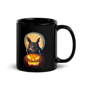 Black 11-ounce bird mug with a great horned owl sitting behind a jack-o-lantern with a full moon rising behind.