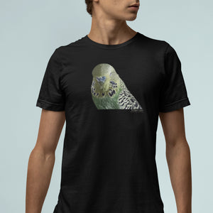 Black unisex t-shirt with an illustrated and lifelike graphic of a green and yellow parakeet or budgie on the front. Below and to the right of the picture is the word Budgerigar and below that the scientific name in parenthesis in small print. Worn by a man.