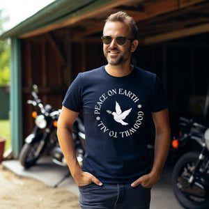 Navy blue unisex bird t-shirt that says Peace on Earth Goodwill to All in a circle surrounding a dove of peace. Worn by a man.