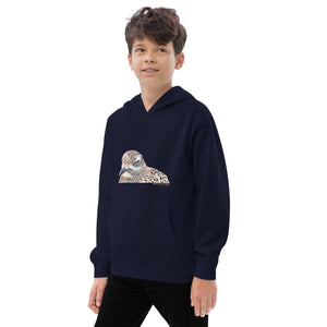 Navy unisex youth bird hoodie with an illustrated picture of a spotted thick-knee bird looking grumpy. The words spotted thick-knee are written below the illustration, including the scientific name. Worn by a boy.