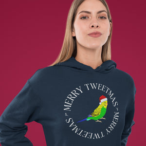 Navy blue unisex bird hoodie with a budgie in a santa hat surrounded by the words Merry Tweetmas, separated by to seed sprigs. Worn by a woman.