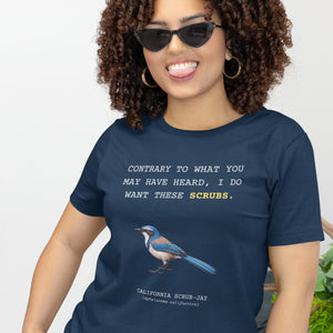 A navy blue unisex bird shirt with the words I want these scrubs on the front above an illustration of a California scrub-jay. Worn by a woman.