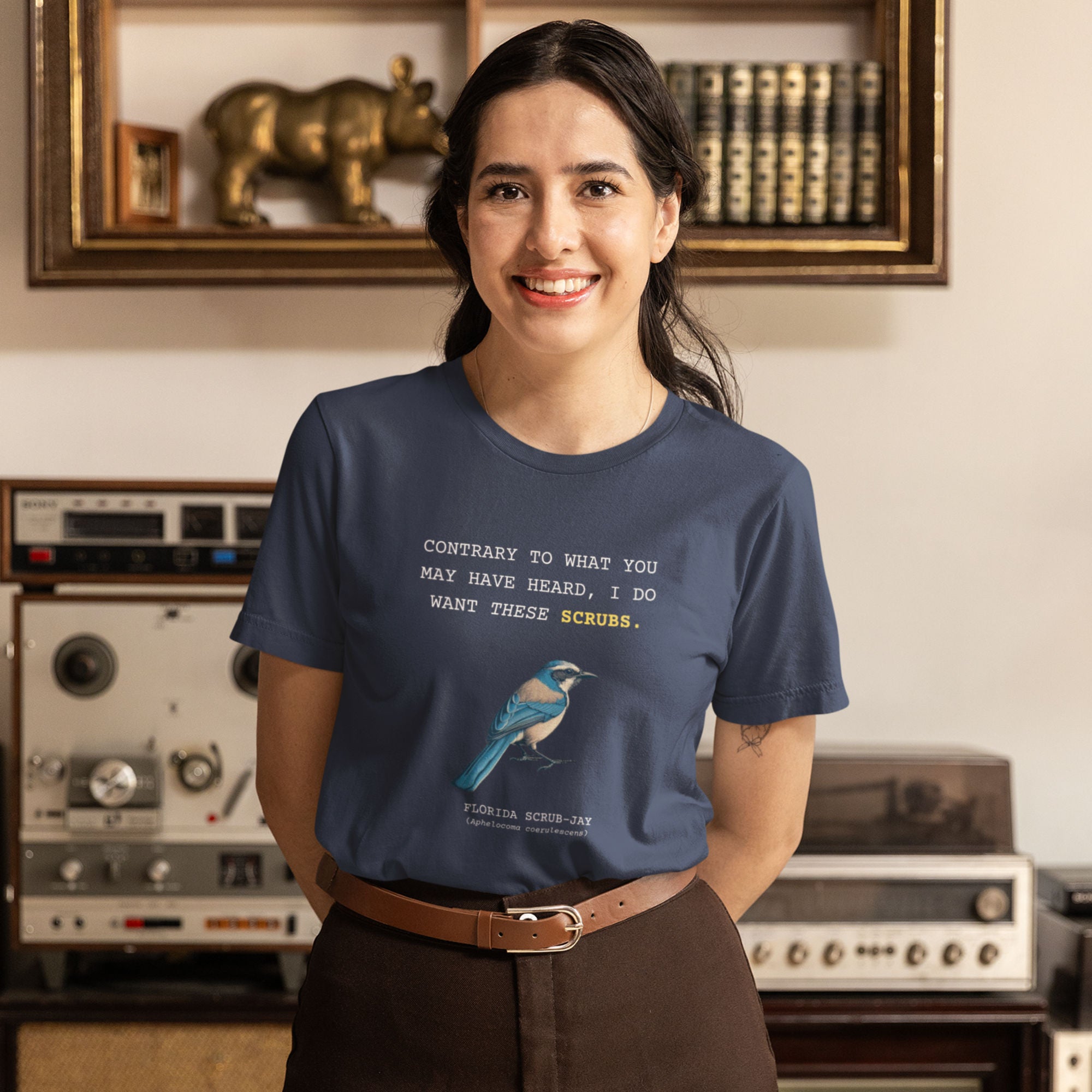 Navy blue unisex bird shirt with the words I do want these scrubs on the front above an illustration of a Florida scrub-jay. Worn by a woman.