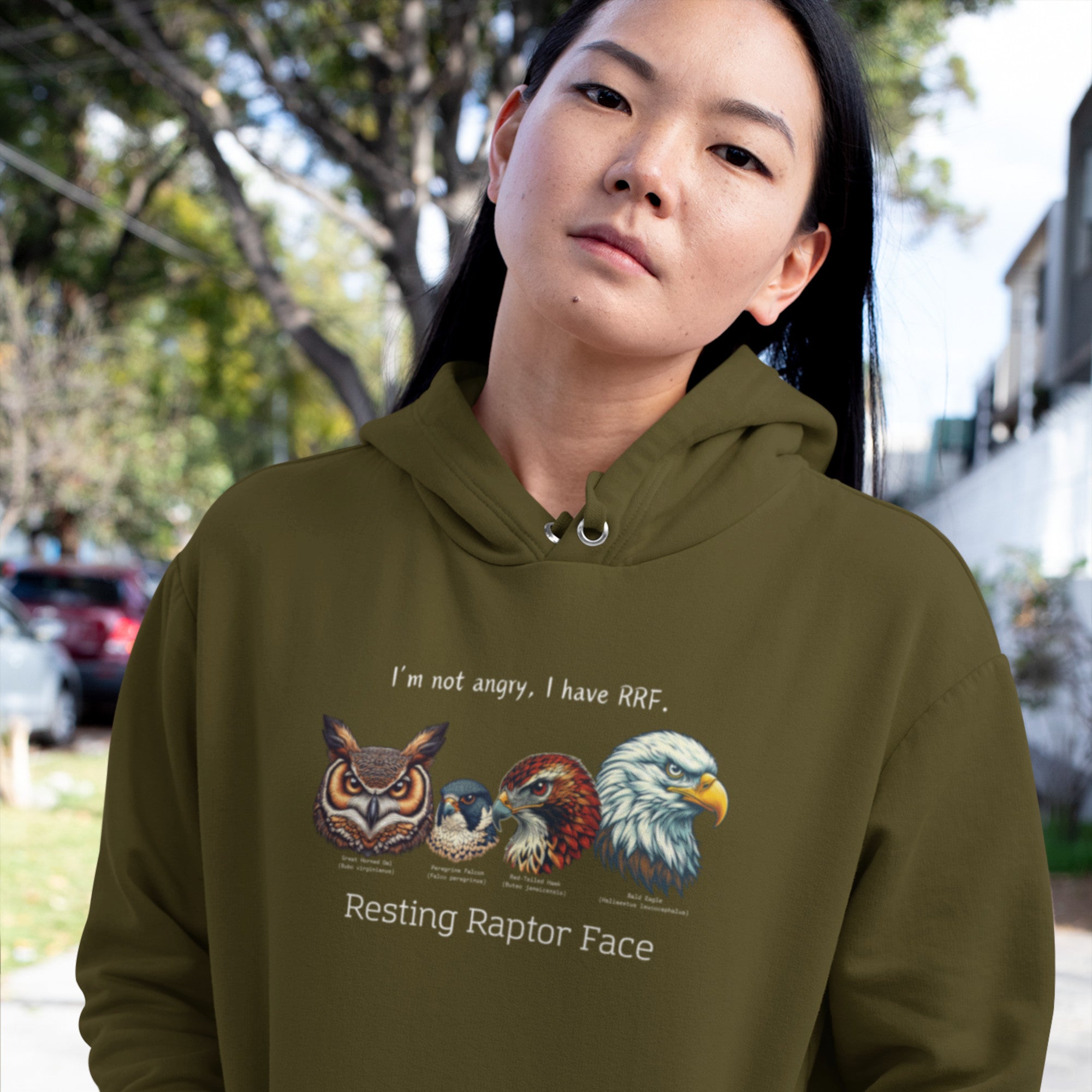 A military green bird hoodie with a great horned owl, a peregrine falcon, a red-tailed hawk and a bald eagle. The shirt has text that says, I'm not angry, I have RRF. Resting Raptor Face.