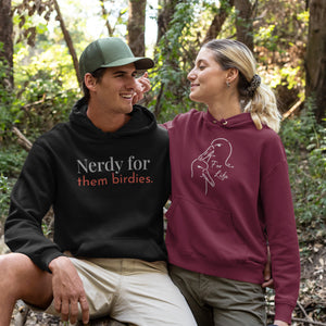 Maroon unisex bird hoodie featuring a line drawing of two Albatross heads and the words "For Life" on the front. Worn by a woman on a hike looking lovingly at her partner who is wearing a Nerdy for them Birdies Hoodie, because he is also awesome.