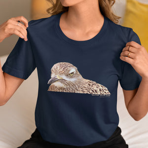 Navy unisex bird shirt with a lifelike illustration of a Spotted Thickknee on the front and the words Spotted Thickknee in small print below, with the scientific name included. Worn by a woman.