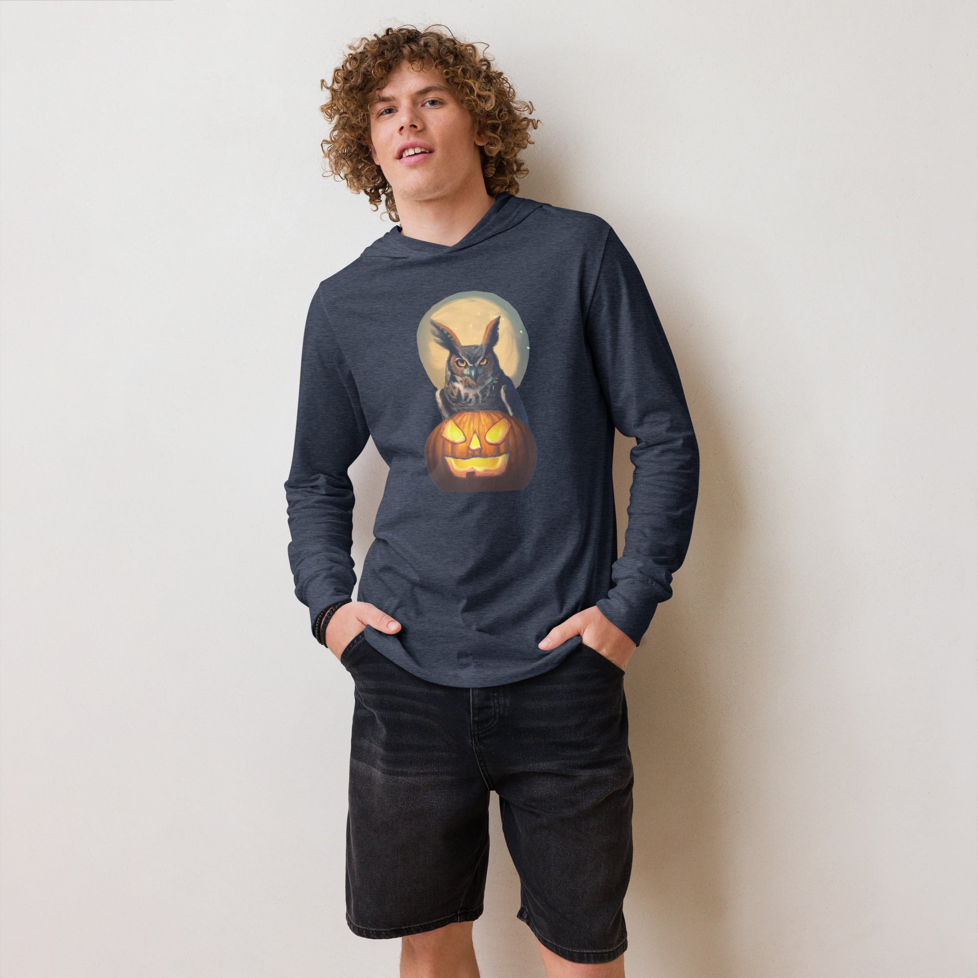 Navy heather, long-sleeve, hooded bird t-shirt with a great horned owl sitting behind a pumpkin, outlined by the full moon. Worn by a man.