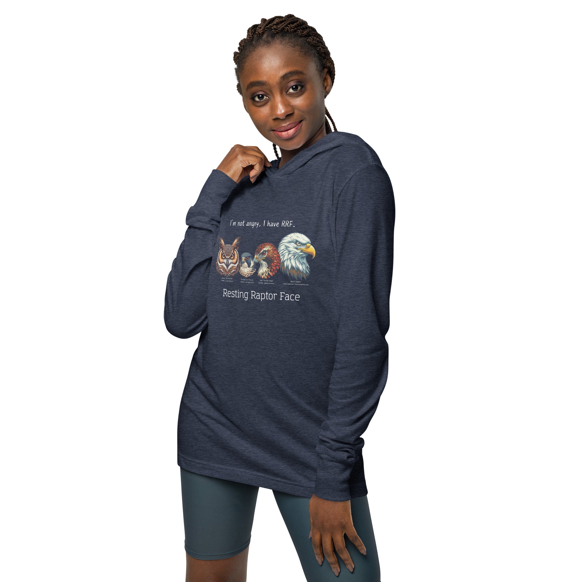 Navy heather long-sleeved, hooded bird tee with illustrations of a Great Horned Owl, Peregrine, Red-Tailed Hawk and Bald Eagle and the words "I'm Not Angry, I have RRF. Resting Raptor Face" above and below the birds. Worn by a woman.