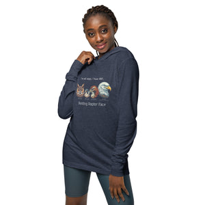 Navy heather long-sleeved, hooded bird tee with illustrations of a Great Horned Owl, Peregrine, Red-Tailed Hawk and Bald Eagle and the words "I'm Not Angry, I have RRF. Resting Raptor Face" above and below the birds. Worn by a woman.