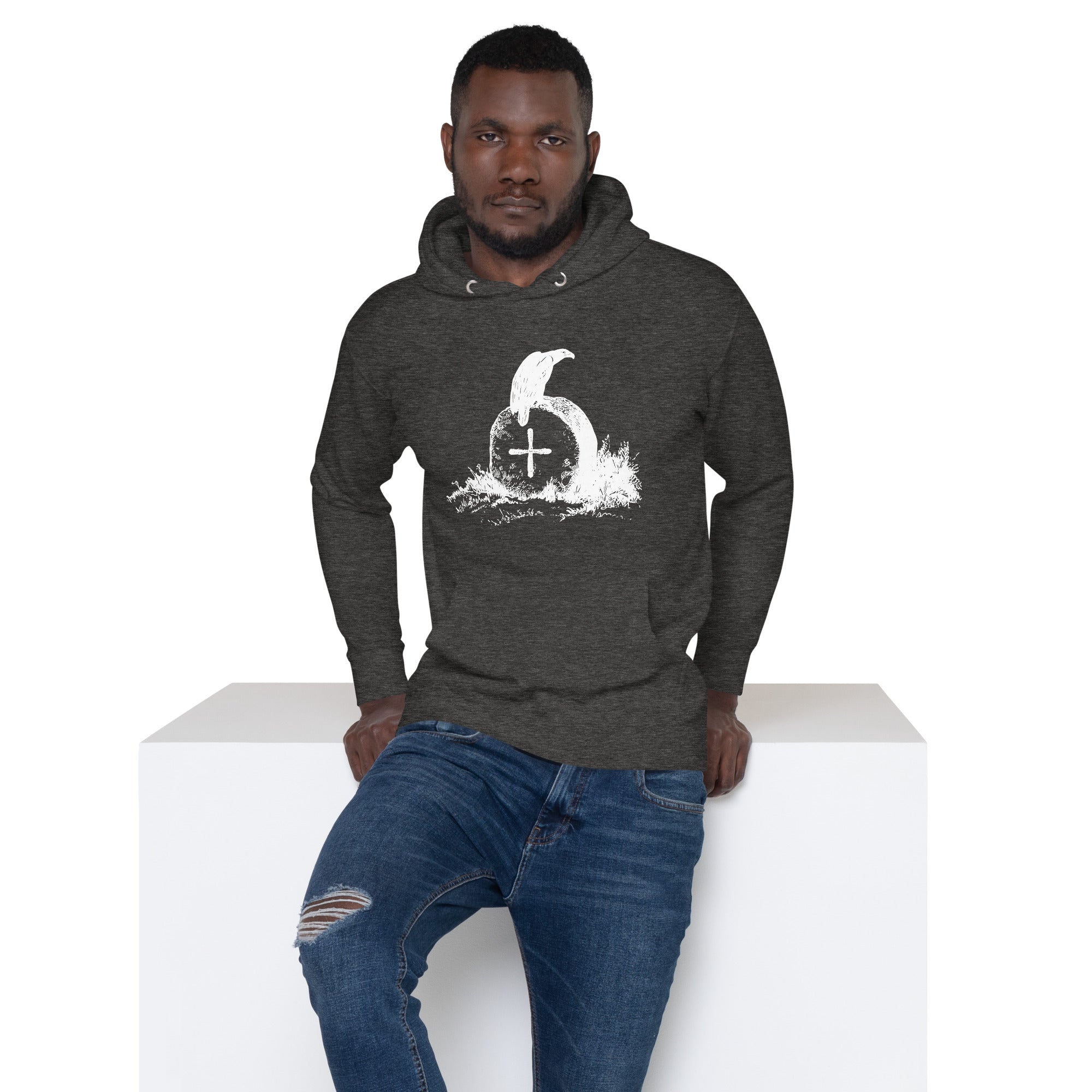 Dark heather grey unisex bird hoodie with a picture of raven sitting on top of an unmarked grave. Worn by a man.