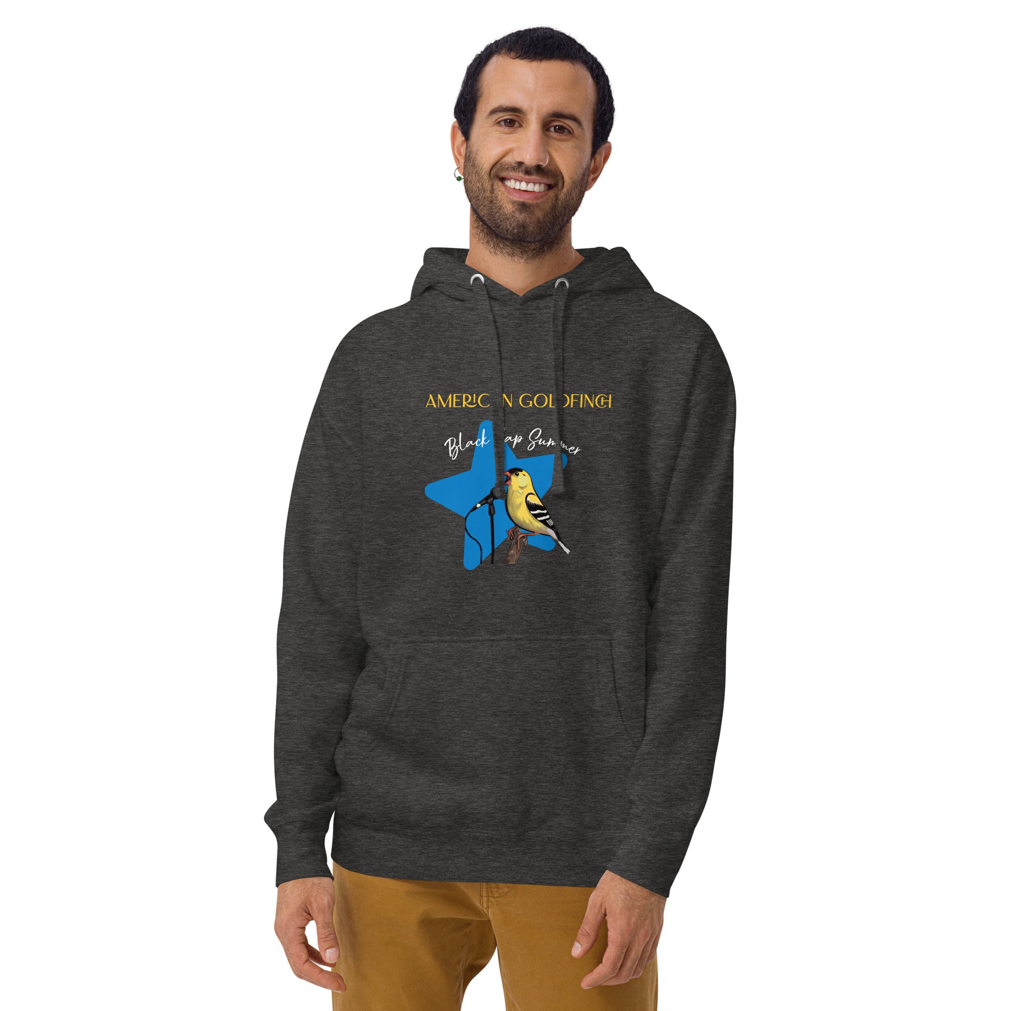 Dark heather gray unisex bird hoodie featuring an American goldfinch singing into a microphone with a list of dates and cities on the back where the american goldfinch is commonly seen. Worn by a man.