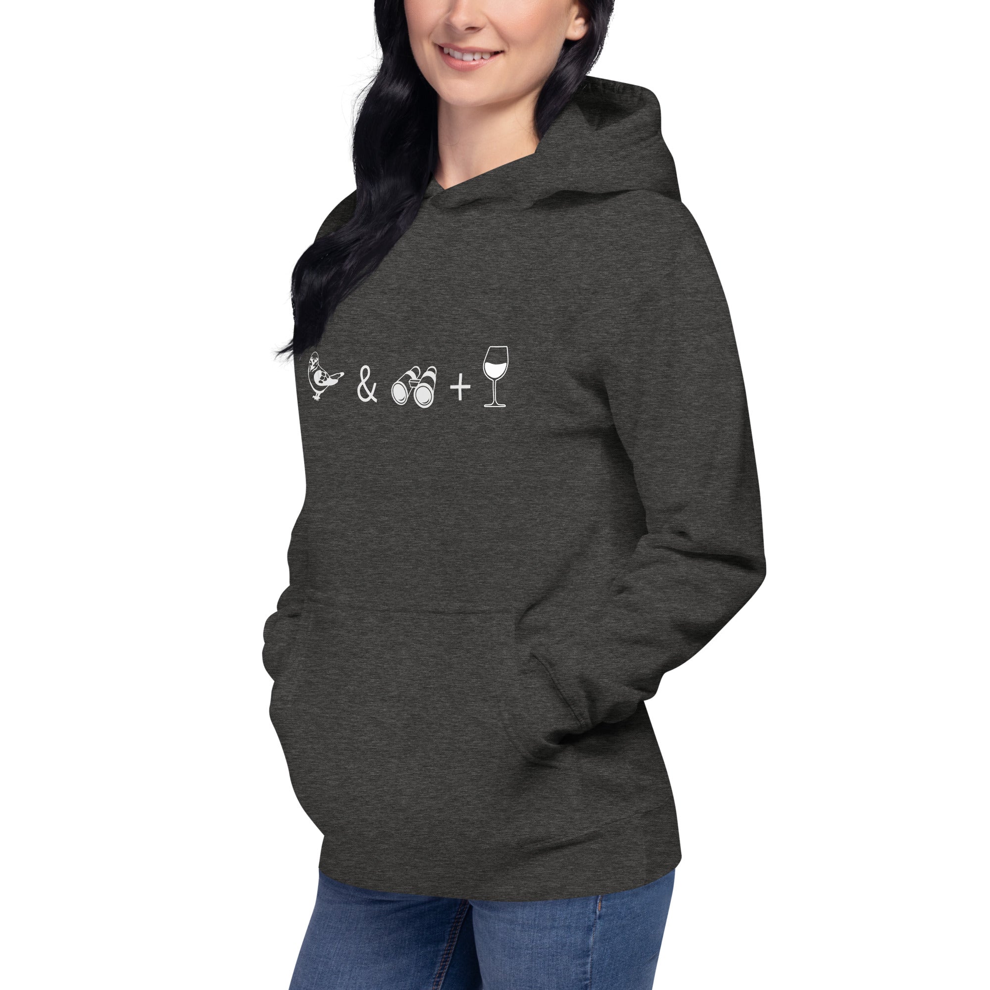 Unisex dark heather hooded bird sweatshirt celebrating bird watching and wine drinking with a graphic of binoculars, a bird, and a glass of wine. Worn by a woman.