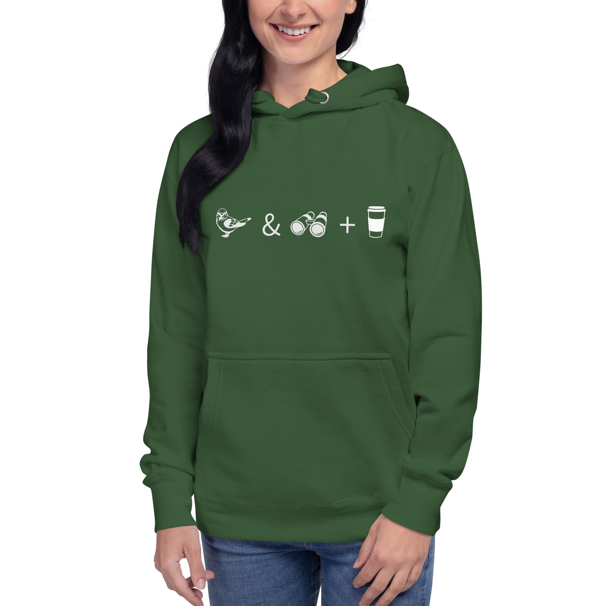 Unisex forest green hooded bird sweatshirt celebrating bird watching and coffee with a graphic of binoculars, a bird, and a travel cup of coffee. Worn by a woman.