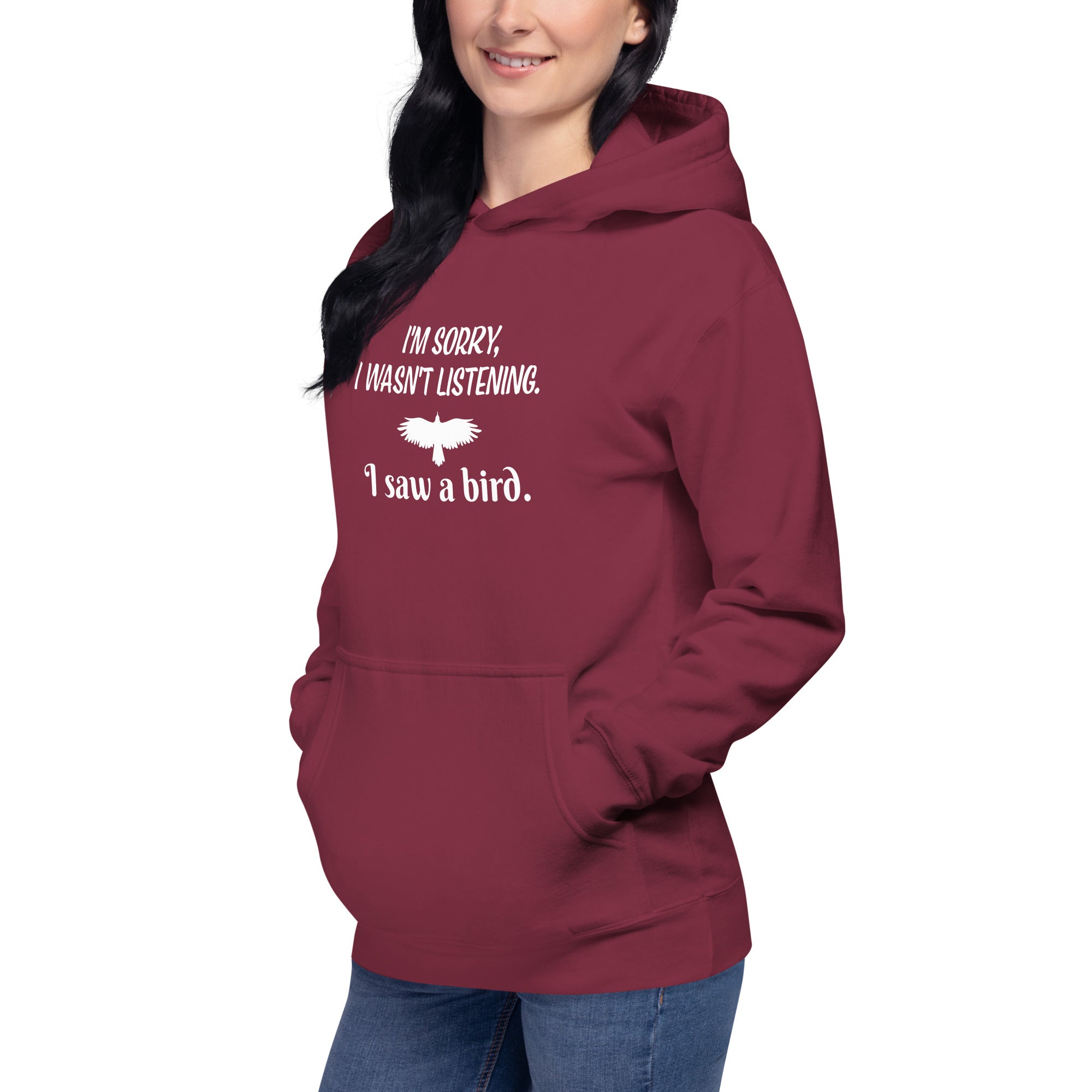 Maroon unisex bird hoodie with the words I'm sorry I wasn't listening, I saw a bird. And a graphic of a bird flying. Worn by a woman.