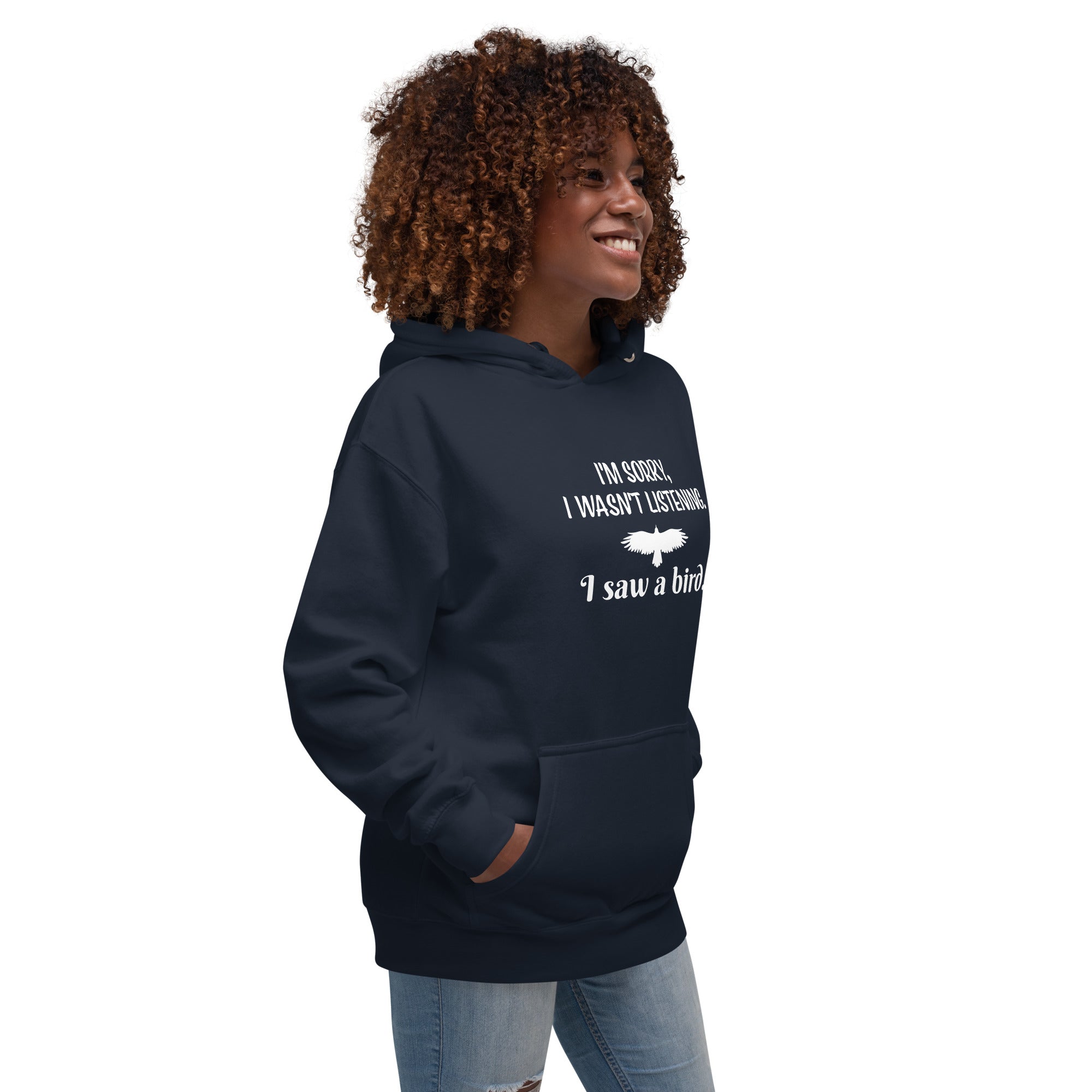 Navy blue unisex bird hoodie with the words I'm sorry I wasn't listening, I saw a bird. And a graphic of a bird flying. Worn by a woman.