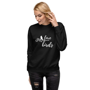 Black birding sweatshirt with the words Love birds and a graphic of a bird on a branch in white. Worn by a woman.