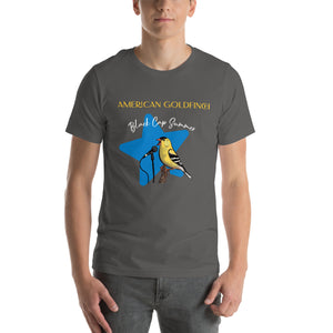 Dark gray unisex bird shirt featuring an American goldfinch singing into a microphone with a list of dates and cities on the back where the bird is commonly seen. Worn by a man.