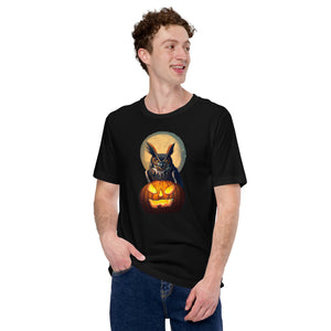 Black bird t-shirt with a great horned owl sitting behind a jack-o-lantern with a full moon rising behind. Worn by a man.