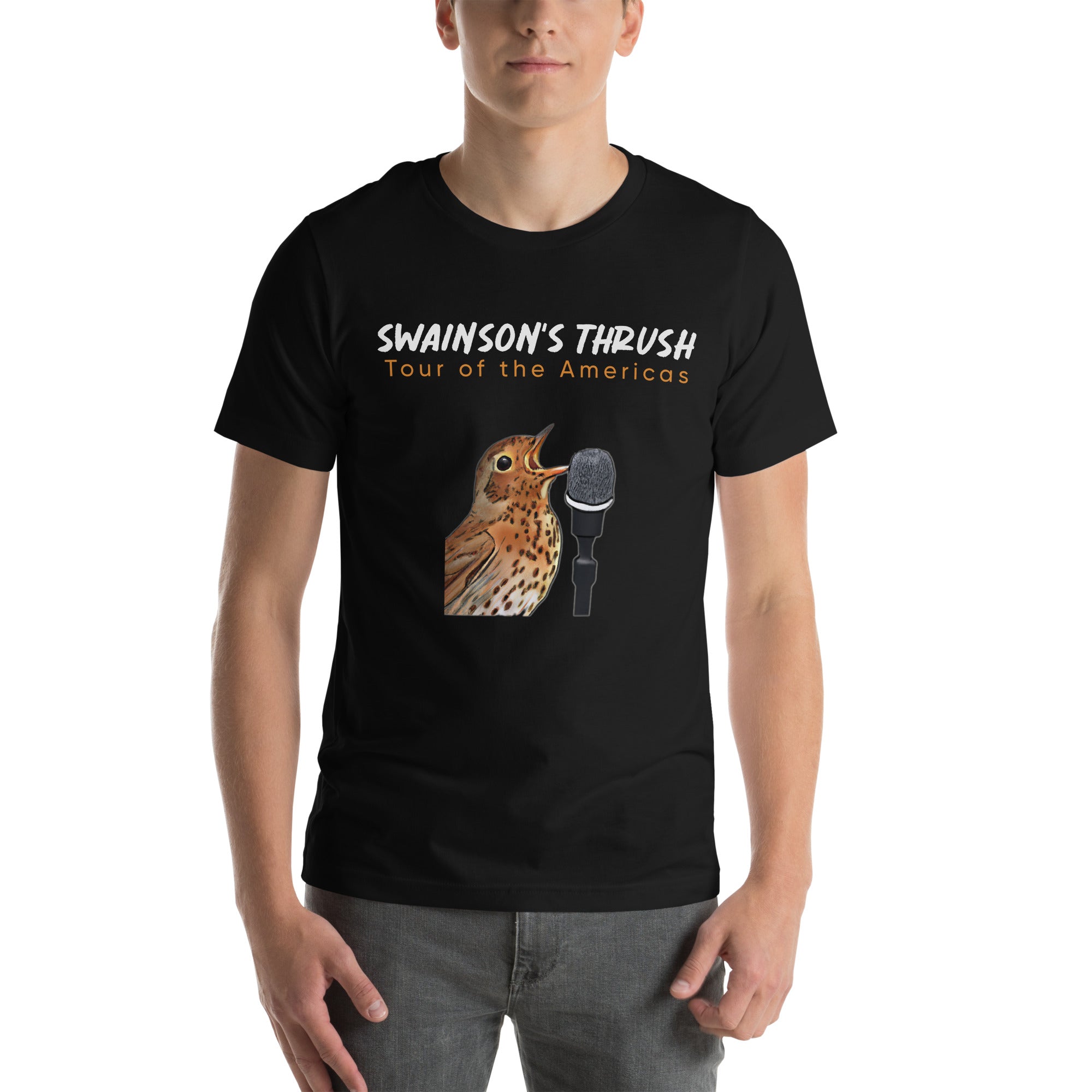 Black unisex bird shirt mimicking a concert t-shirt with the words "Swainson's Thrush" and below that, "Tour of the Americas" and below that an illustrated Swainson's thrush singing into a microphone. Back of shirt, (not shown) has concert dates and cities where this bird can be heard. Worn by a man.