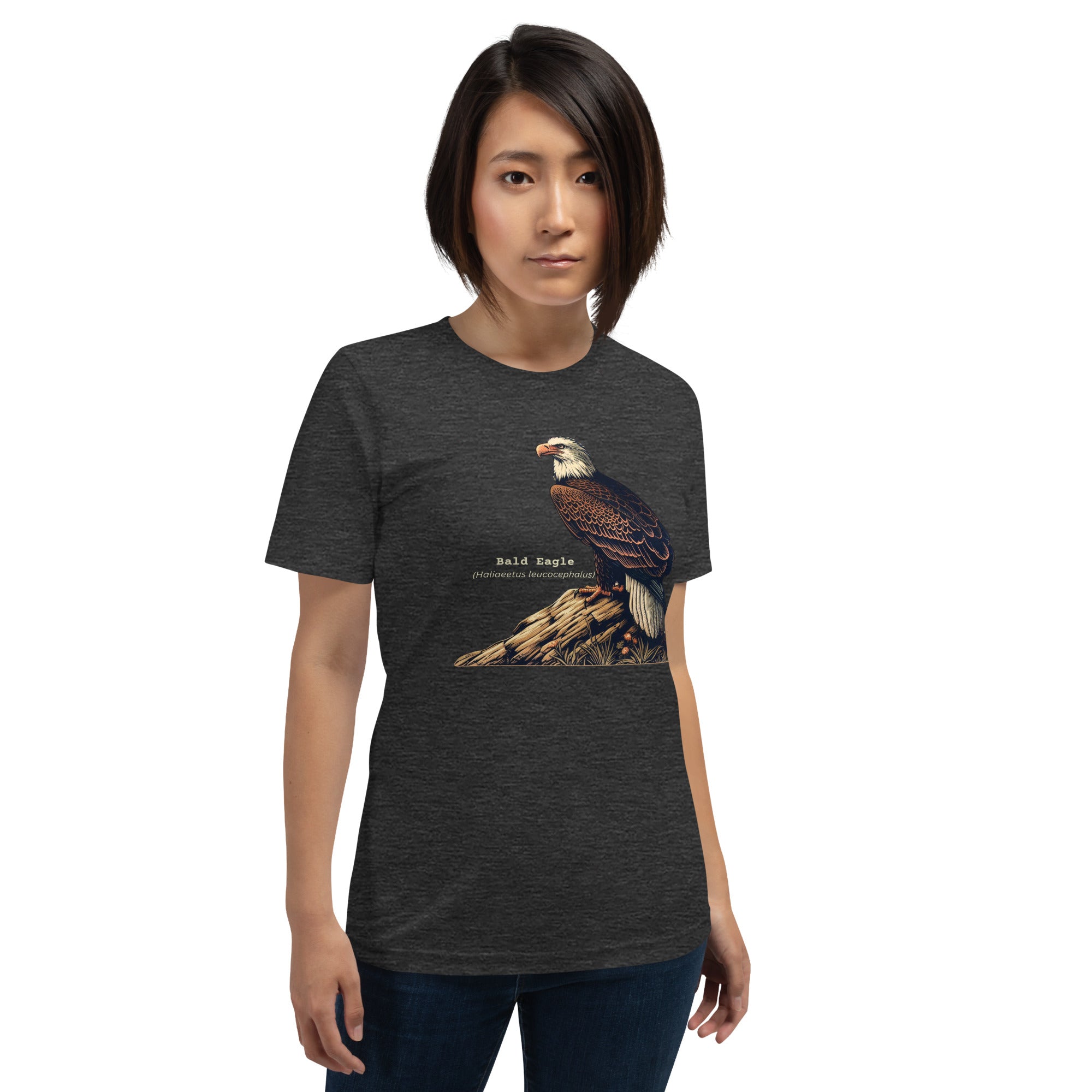 Dark Gray heather unisex bird shirt with a Bald Eagle perched on a rock, next to its common and scientific names. Worn by a woman.