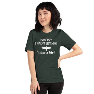 Heather forest green bird t-shirt with the words I'm sorry I wasn't listening, I saw a bird. And a graphic of a bird flying. Worn by a female model.