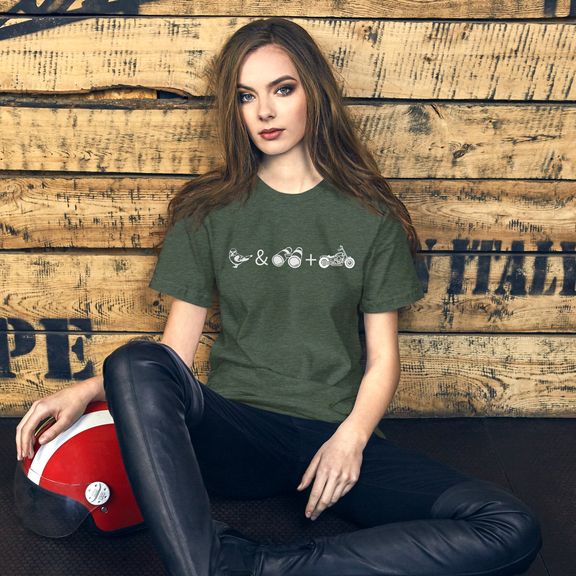 Unisex forest green heather bird t-shirt celebrating bird watching and motorcycling with a graphic of binoculars, a bird, and a motorcycle.  Worn by a woman.