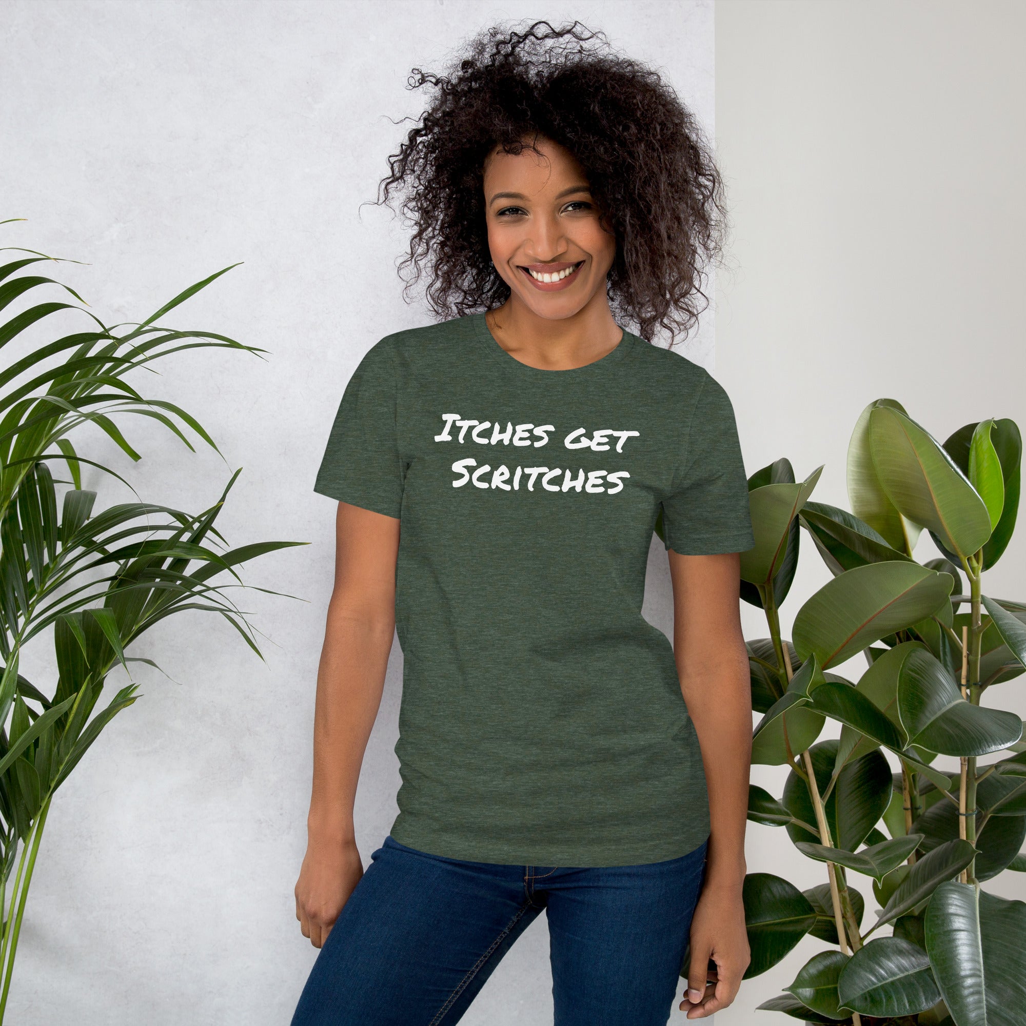 Forest green unisex t-shirt with the phrase, "Itches get scritches" across the front. Worn by a woman.