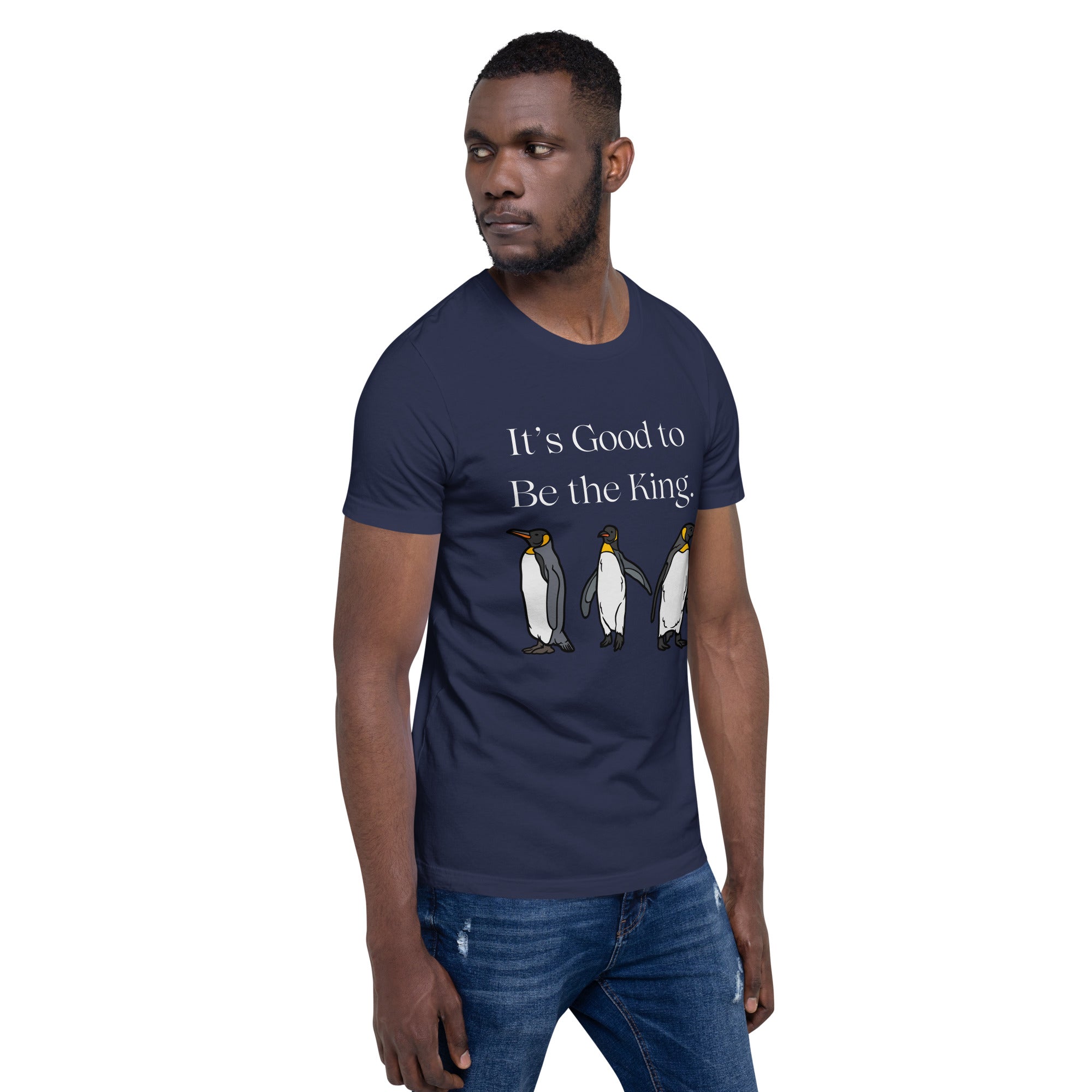 Navy blue unisex bird shirt with three king penguins below the phrase, "It's Good to Be The King." Worn by a man.