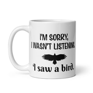 White 11oz mug with the words "I'm Sorry I Wasn't Listening. I Saw a Bird." around the silhouette of a bird flying.