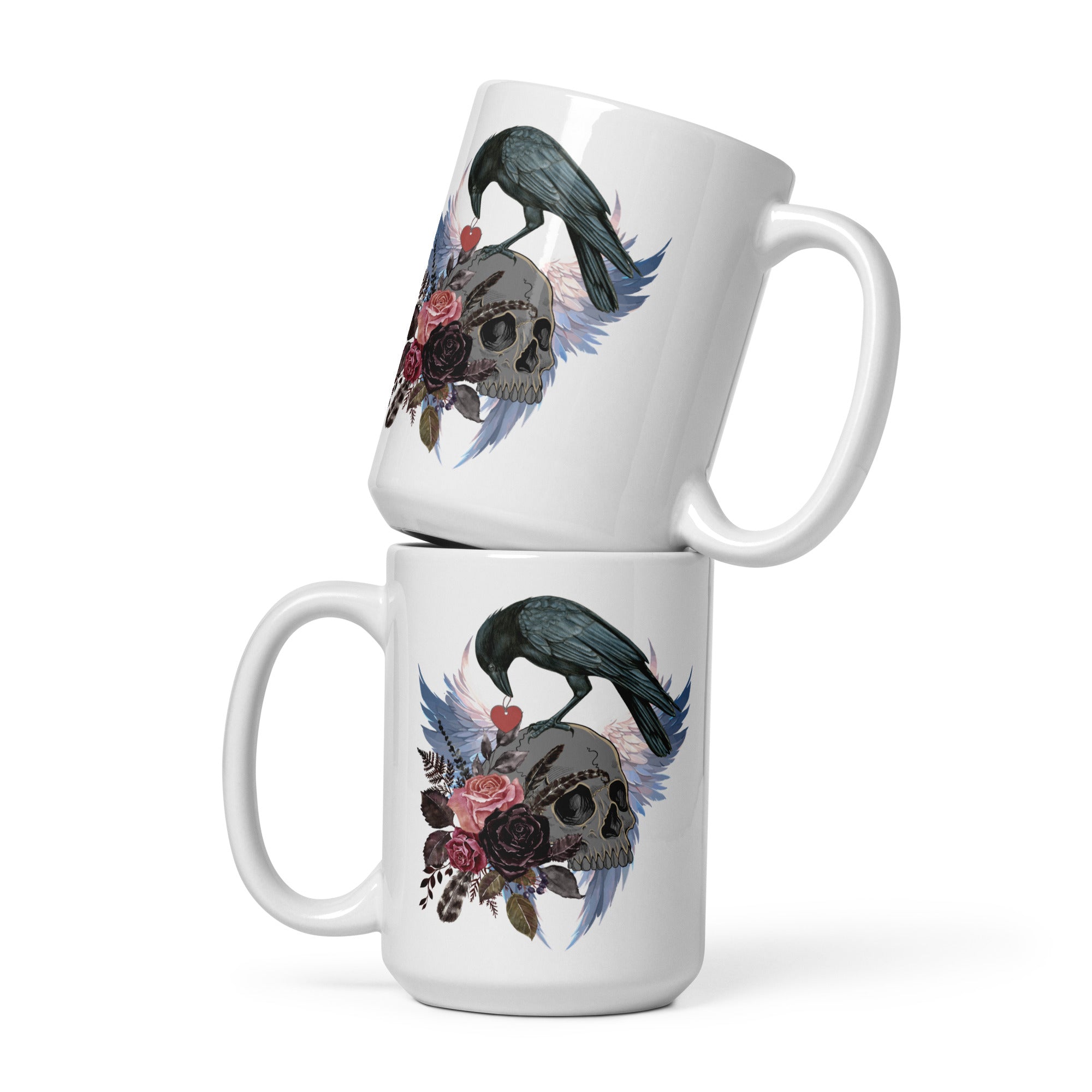 Gothic themed white 15-ounce bird mug with a crow carrying a heart pendant, perched on a skull surrounded by flowers, feathers and wings.