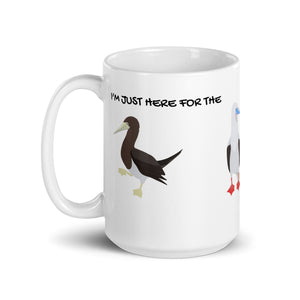 white glossy 15 ounce mug with illustrations of the blue-footed, red-footed and brown booby and the words, "I'm just here for the Sulidae." Mug handle to the left.