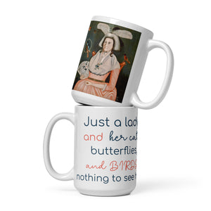 Coffee mug with a remaster version of Lady and her Pets on one side and the words, "Just a lady and her cat, butterflies, and Birds..., nothing to see here." on the the other side.