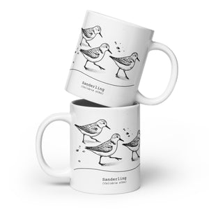 White 20-ounce mug featuring an illustration of a three sanderlings on a beach and the common and scientific names for the bird underneath.