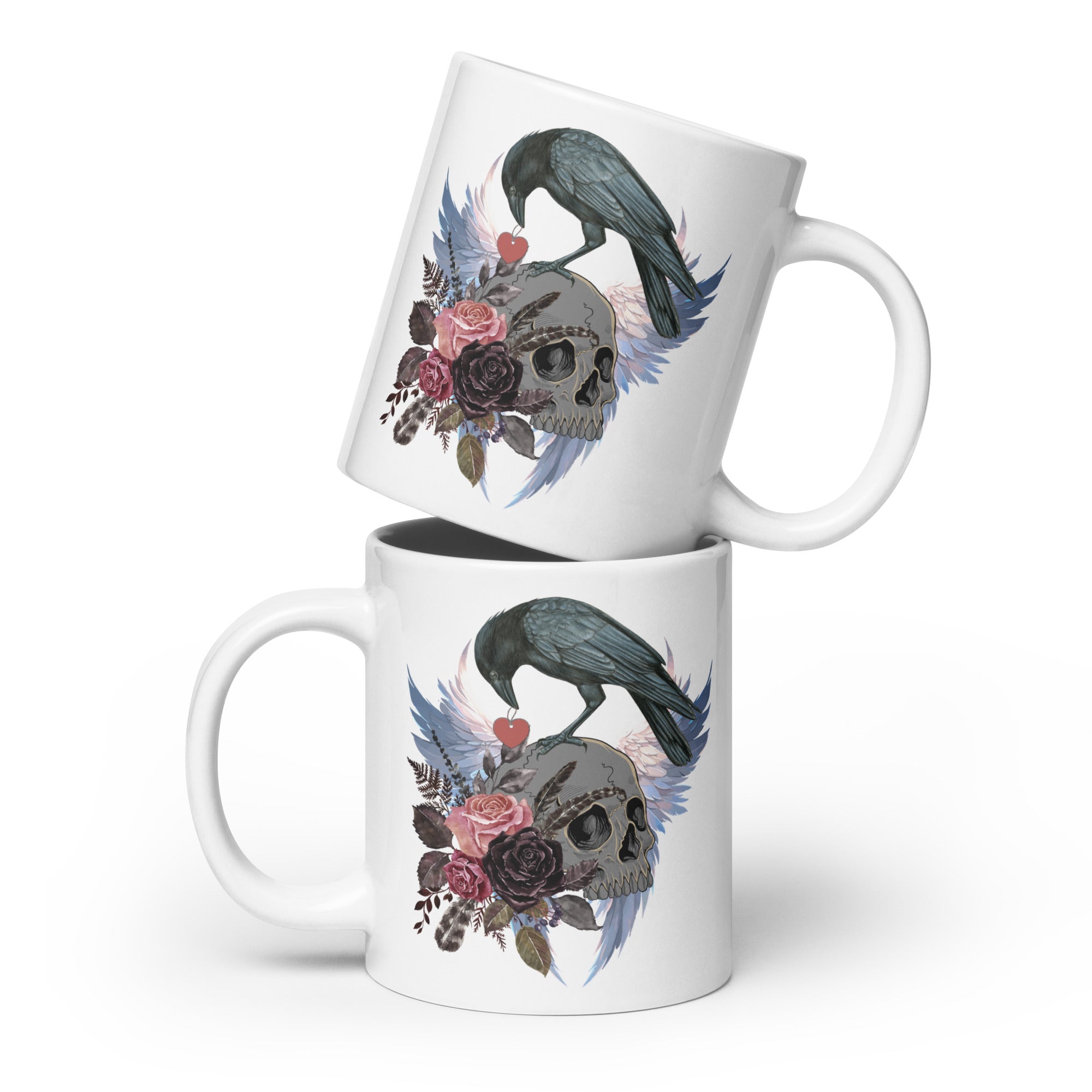 Gothic themed white 20-ounce bird mug with a crow carrying a heart pendant, perched on a skull surrounded by flowers, feathers and wings.