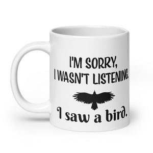 White 20oz mug with the words "I'm Sorry I Wasn't Listening. I Saw a Bird." around the silhouette of a bird flying.