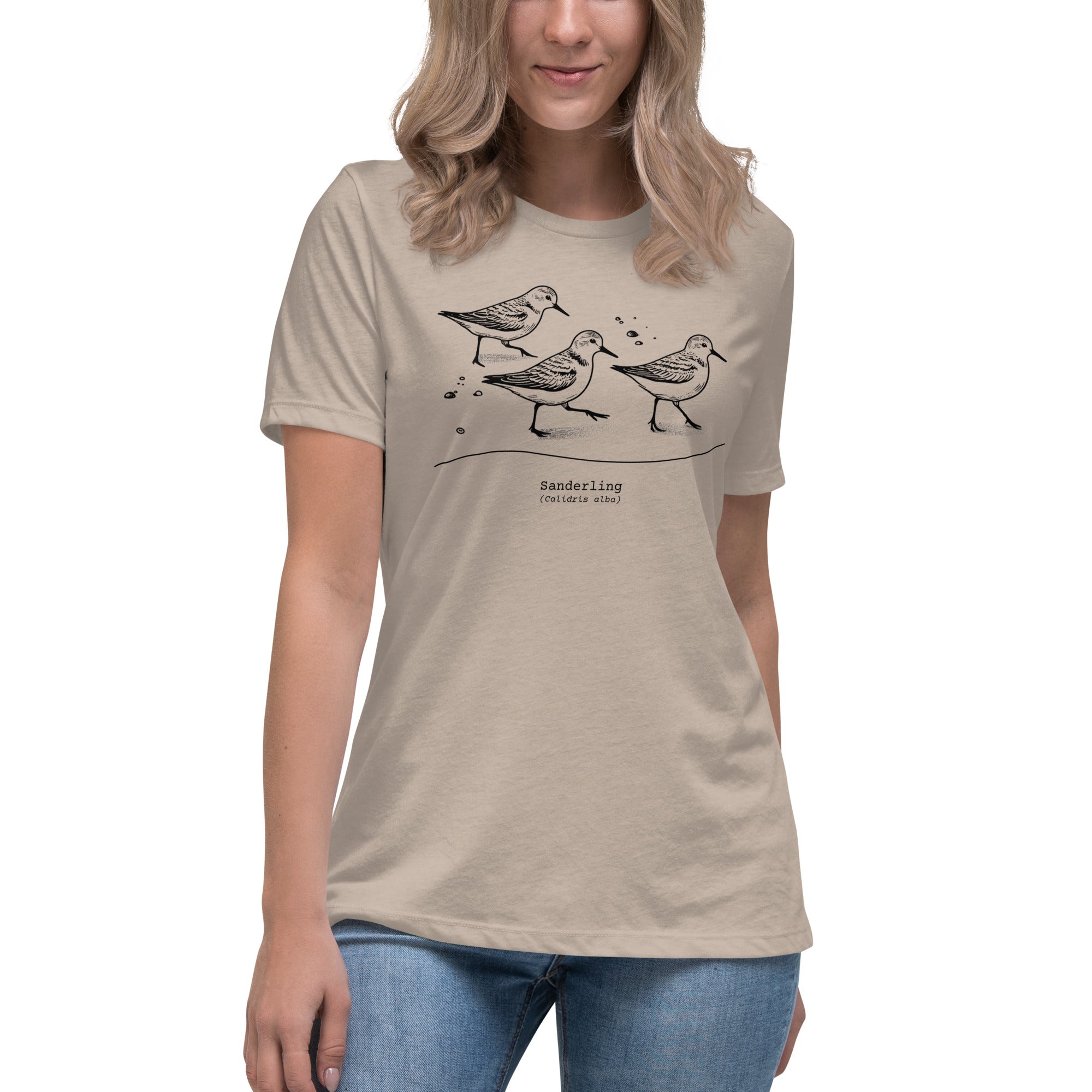 Heathered taupe bird shirt featuring an illustration of a three sanderlings on a beach and the common and scientific names for the bird underneath. Worn by a woman.