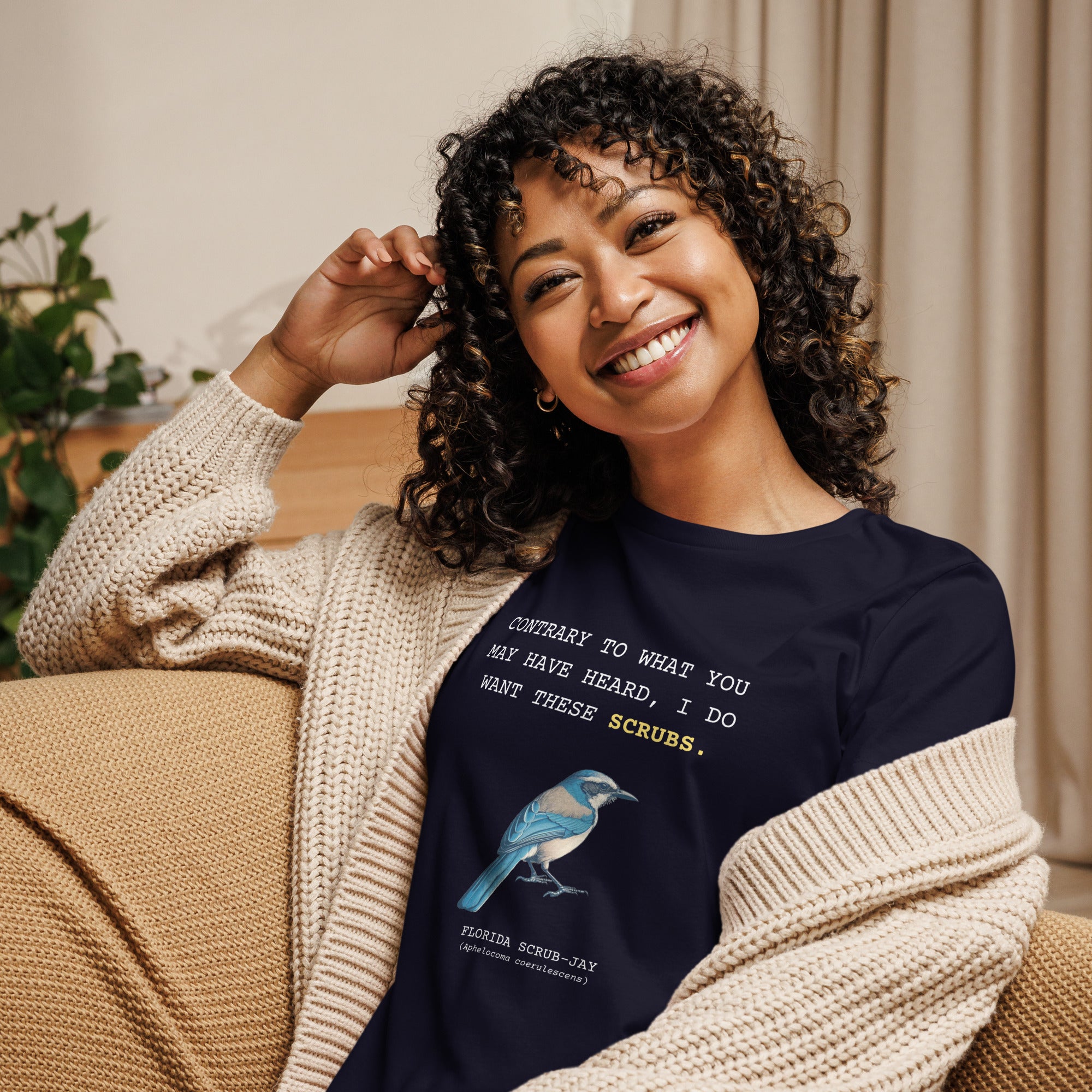 Navy blue women's bird shirt with the words I want these scrubs on the front above an illustration of a Florida scrub-jay. Worn by a woman.