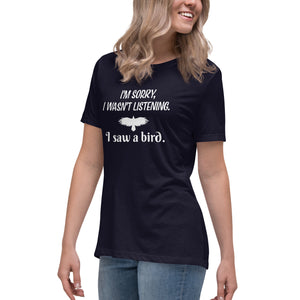 Navy blue women's bird t-shirt with the words I'm sorry I wasn't listening, I saw a bird. And a graphic of a bird flying. Worn by a woman.